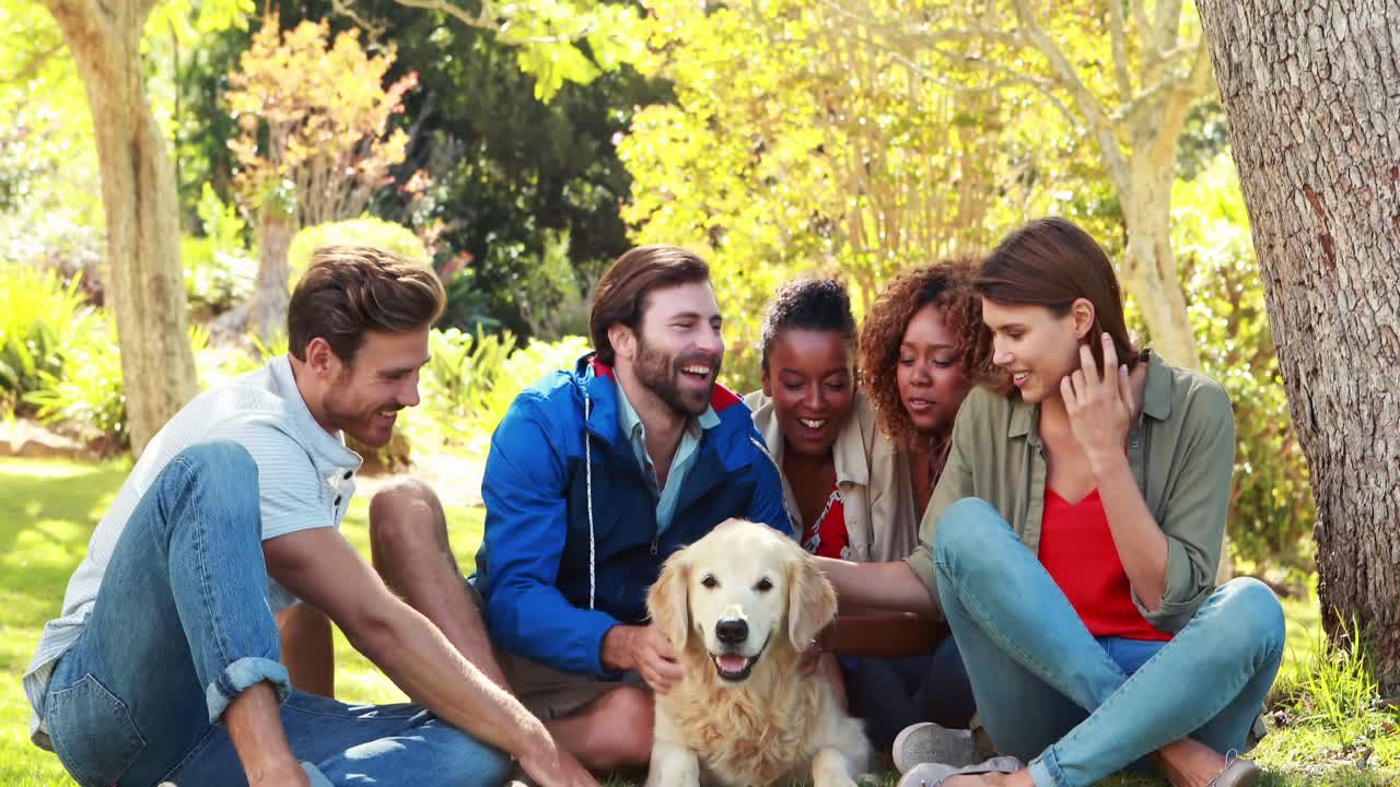 grupo de amigos felices sentados juntos con el perro