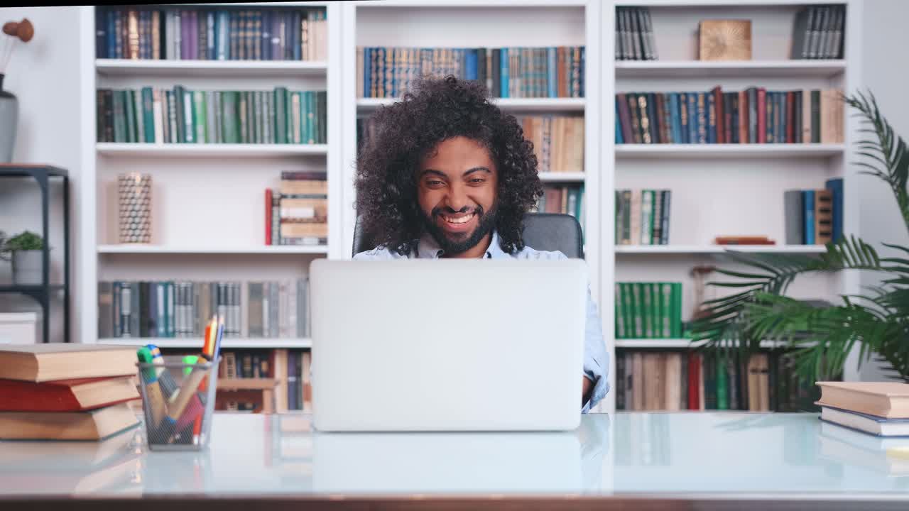 Young inspired indian man opens laptop and starts actively typing
