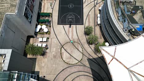 capturing a modern mega shopping mall with a basketball court from drone's eye view