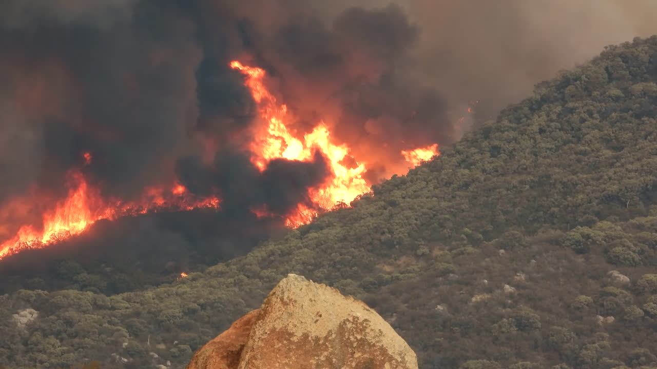 enormes llamas y espeso humo negro del devastador incendio forestal de fairview, el incendio que destruyó toda la vegetación natural en la ladera de una montaña en hemet, california, ee.uu.