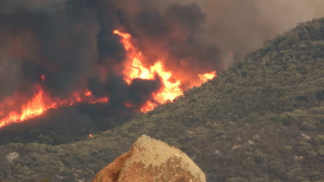 huge flames and thick black smoke from the devastating fairview wildfire, the blaze destroying all the natural vegetation on the side of a mountain in hemet, california, usa