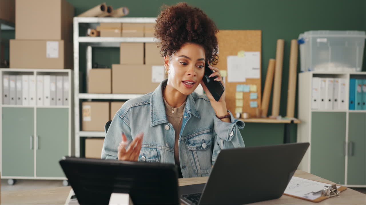 Woman working at desk with laptop and phone