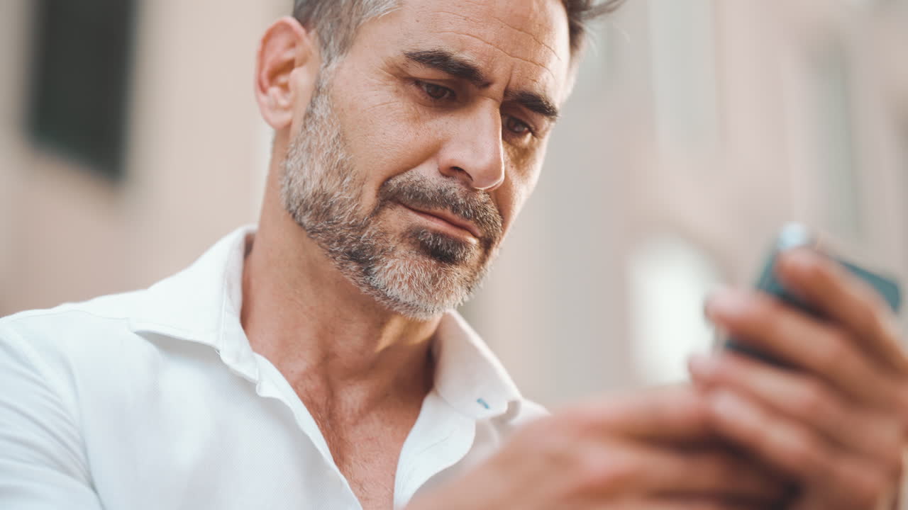 Uomo sorridente mentre usa uno smartphone all'aperto