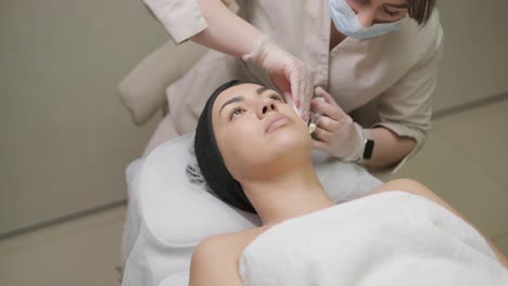 a patient reclines while receiving a facial injection from a clinician in a medical spa setting, highlighting aesthetic treatment without focusing on specific brand names