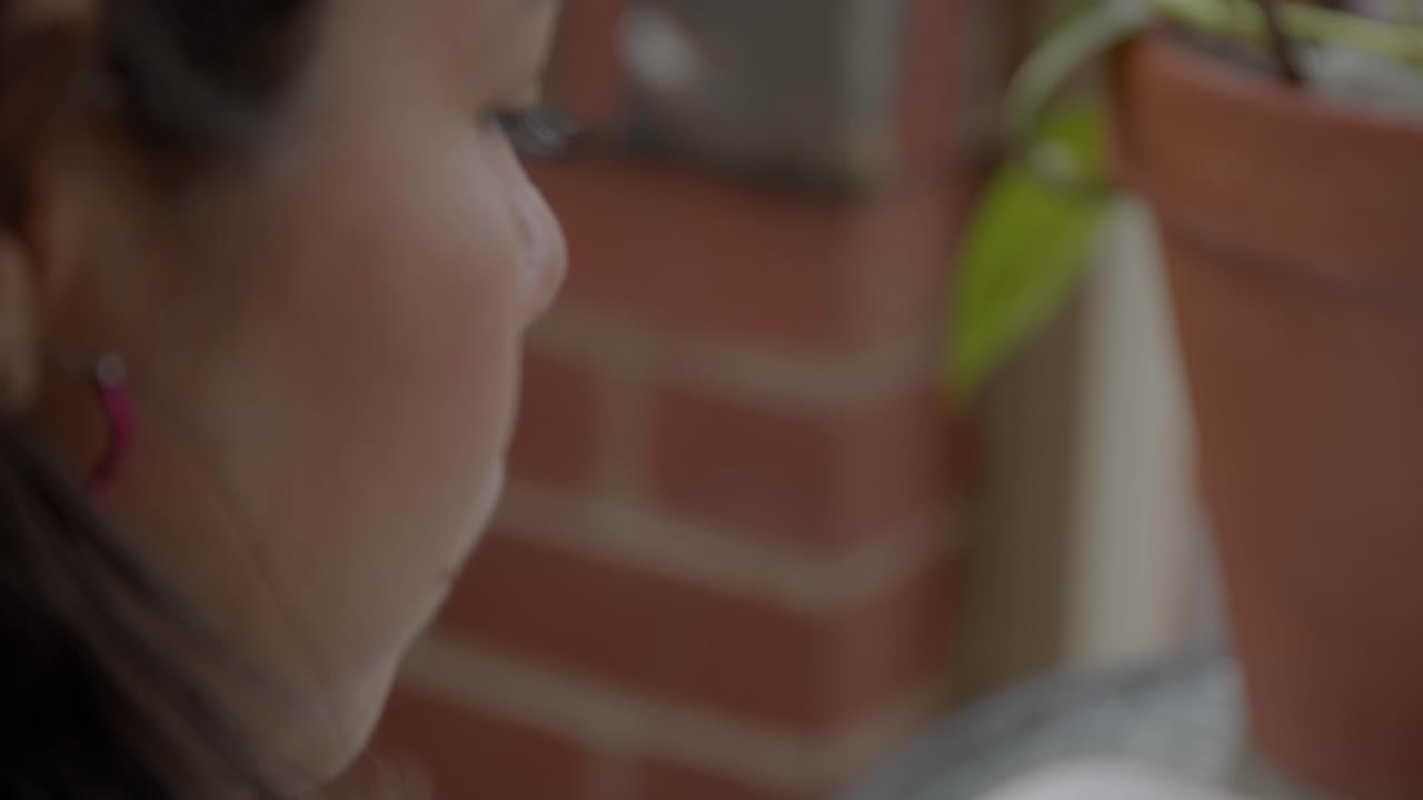 Hispanic latino girl reading the bible with cross, over the shoulder shot