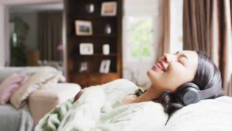 음악 을 듣고 있는 헤드폰 을 사용하는 어두운 머리 를 가진 미소 짓는 두 인종 의 여성 의 비디오