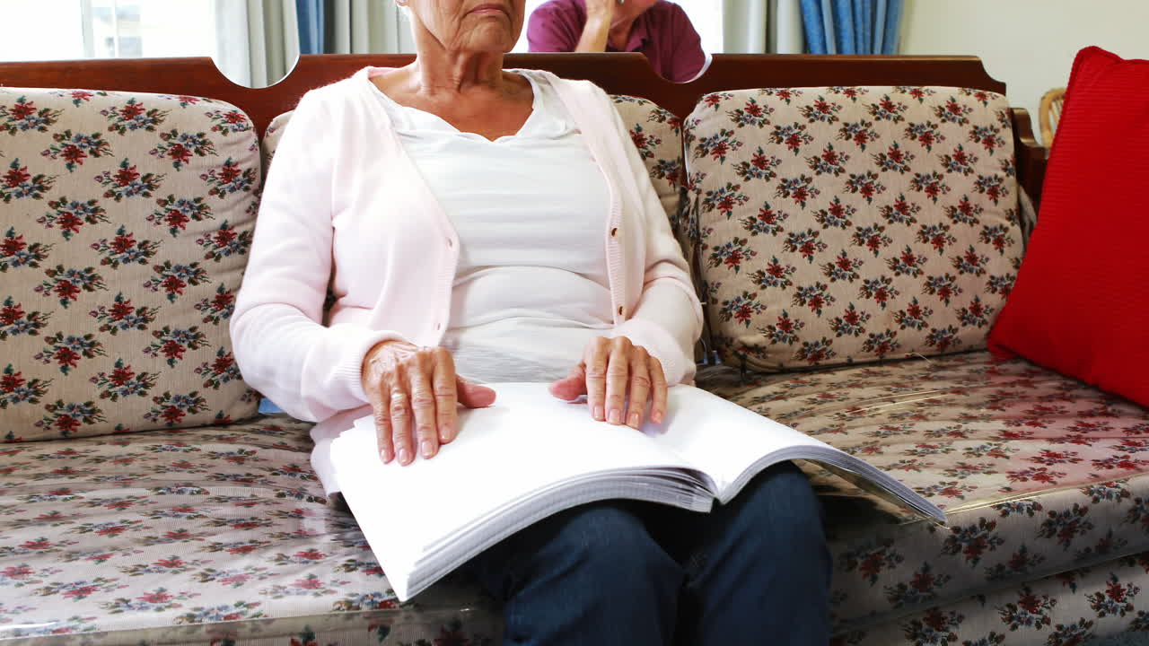 고령 여성 이 브라이일 문자 로 책 을 읽고 있다