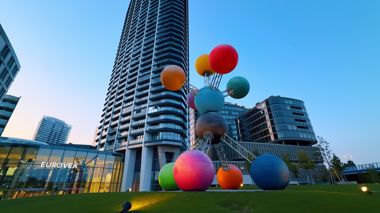 Bratislava, Slovakia, 2 June 2025: Colorful Eurovea sculpture. A colorful sphere sculpture shines at Eurovea in Bratislava, set against modern buildings at dusk