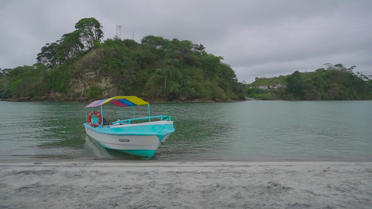 pequeño bote amarrado cerca de la playa de arena en ecuador