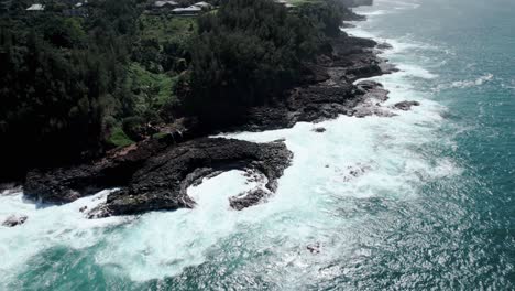 revealing waves crashing on jagged rocks, queen's bath, kauai, hawaii, aerial orbit and pull back