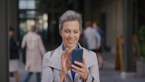 Retrato-De-Una-Mujer-De-Negocios-Independiente-De-Mediana-Edad-Que-Usa-Un-Teléfono-Inteligente-En-La-Ciudad-Y-Disfruta-Navegando-Mensajes-En-Línea-Enviando-Mensajes-De-Texto-En-Un-Teléfono-Móvil-En-Cámara-Lenta