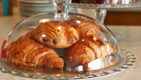 croissant recién horneado en un frasco de vidrio cerrado en una cafetería,