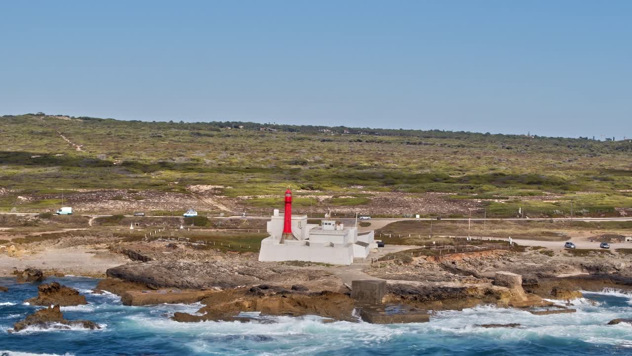 Lighthouse on the coast of Portugal with waves and green landscape