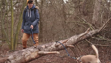 a young woman with short hair takes a walk with her dog in the woods 2