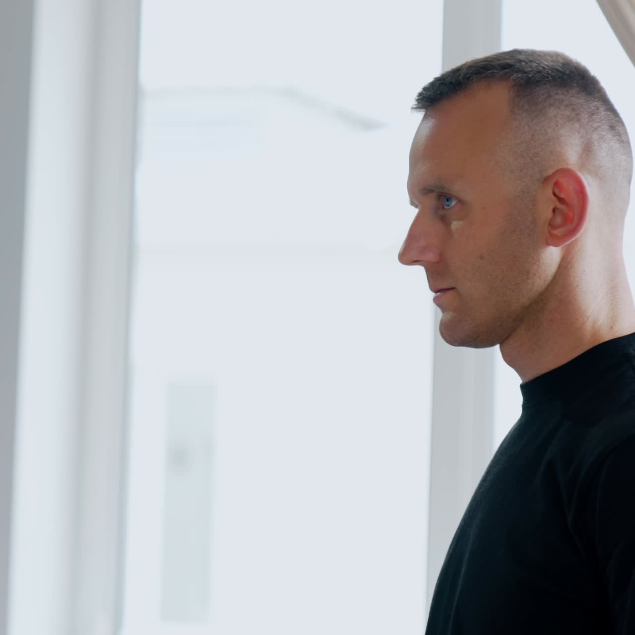 Mid aged Caucasian male standing in the hospital room. Side view portrait. Puzzled and concerned man before wife's labor