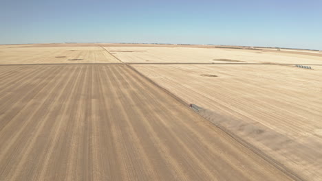 gran camión semi sale del campo con cosecha, rastreando un largo tiro de dron