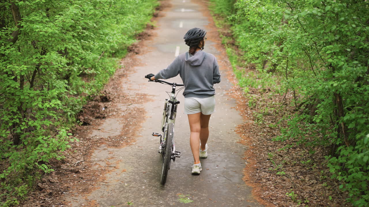 Cyclist Traverses Forest, Traveler Pedals Along Wooded Trail, Young Explorer Searches Through Thick Woodland Pathways, Adventurous Cyclist Carefully Journeys Across Vibrant Green Forest Terrain