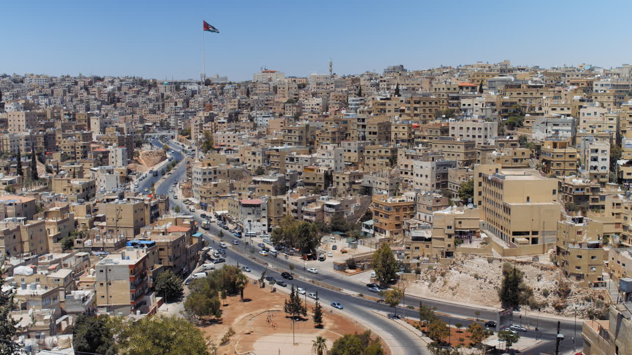 Panorama timelapse of the city of Amman, Jordan with flag view from Jabal Al Qal'a, the Citadel of Amman. Urban Sprawl 4K footage