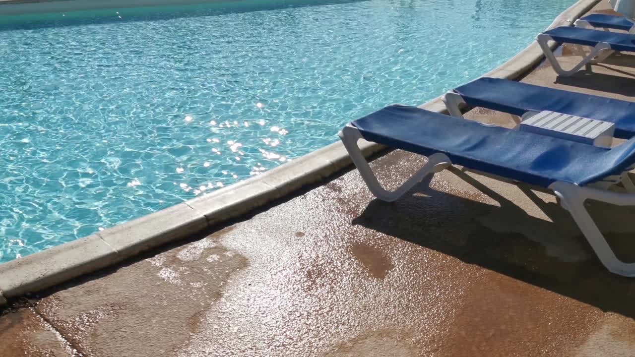 piscina, tumbonas y palmeras durante un cálido día soleado, destino paradisíaco para las vacaciones. patio trasero piscina con jardín lleno de palmeras y flores. patio trasero con piscina