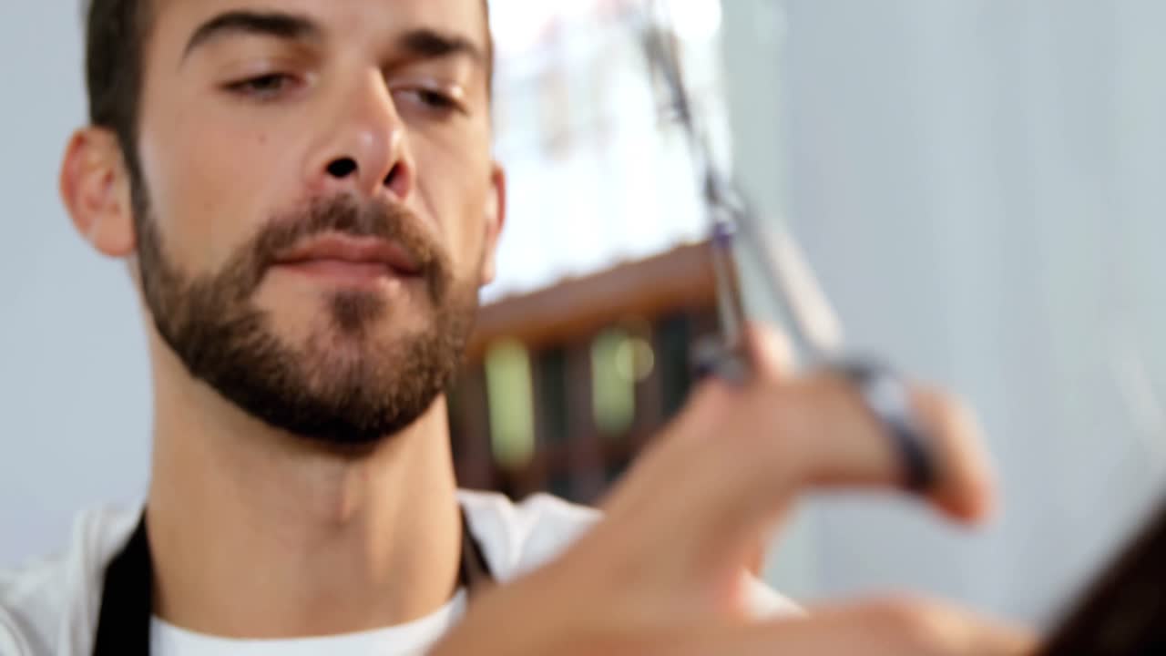 남자 이발사 가 가위 로 여자 의 머리카락 을 자르고 있다