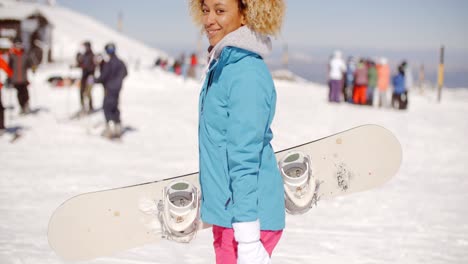 trendy jonge vrouw die haar snowboard draagt