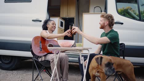 friends enjoying beers and guitar music while van camping