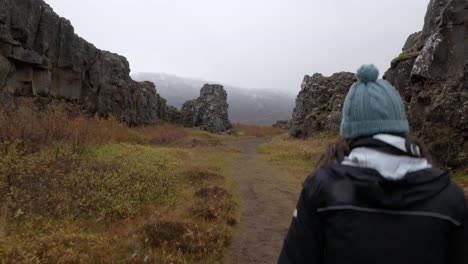 Cinematic-Walk-Along-a-Fault-Line-Young-Woman-Walks-into-Shot