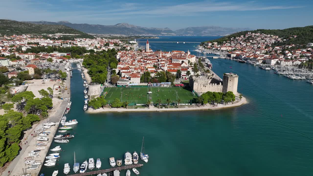 Aerial view of the Trogir Football Field near a medieval castle.