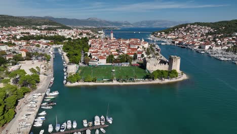 aerial view of the trogir football field near a medieval castle.