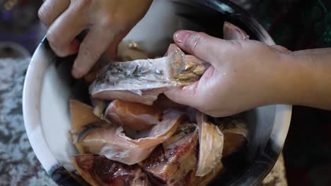 Vista-Aérea-De-Las-Manos-De-La-Cocinera-Pelando-Escamas-De-Pescado-Fresco-En-Un-Tazón