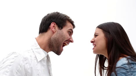 una pareja de jóvenes enojados gritándose el uno al otro.