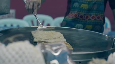 el cocinero trabaja con una espátula de plata y prepara comida deliciosa.