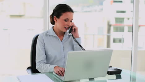 mujer de negocios feliz escribiendo y hablando por teléfono