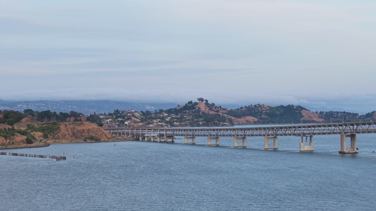 The drone flies slowly over Point Molate Beach, revealing its earthy tones and gently lapping shoreline.
