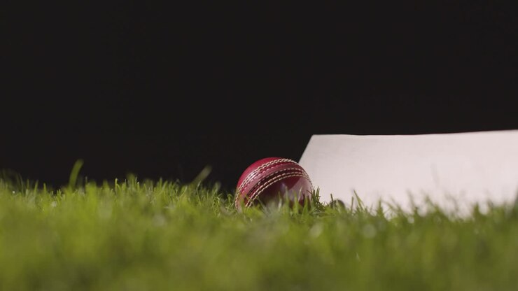 Natura morta da studio di cricket con primo piano di mazza e palla adagiate sull'erba 2