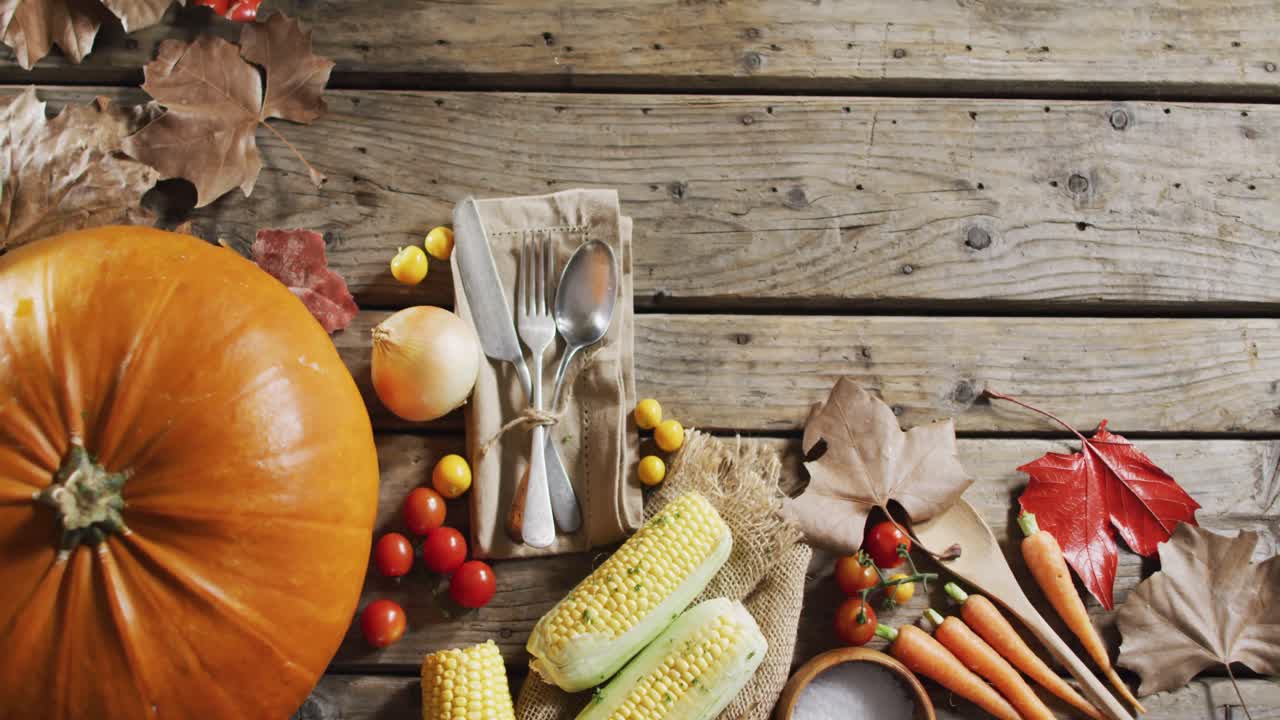 múltiples ingredientes alimentarios, hojas de otoño y cubiertos con espacio de copia en superficie de madera