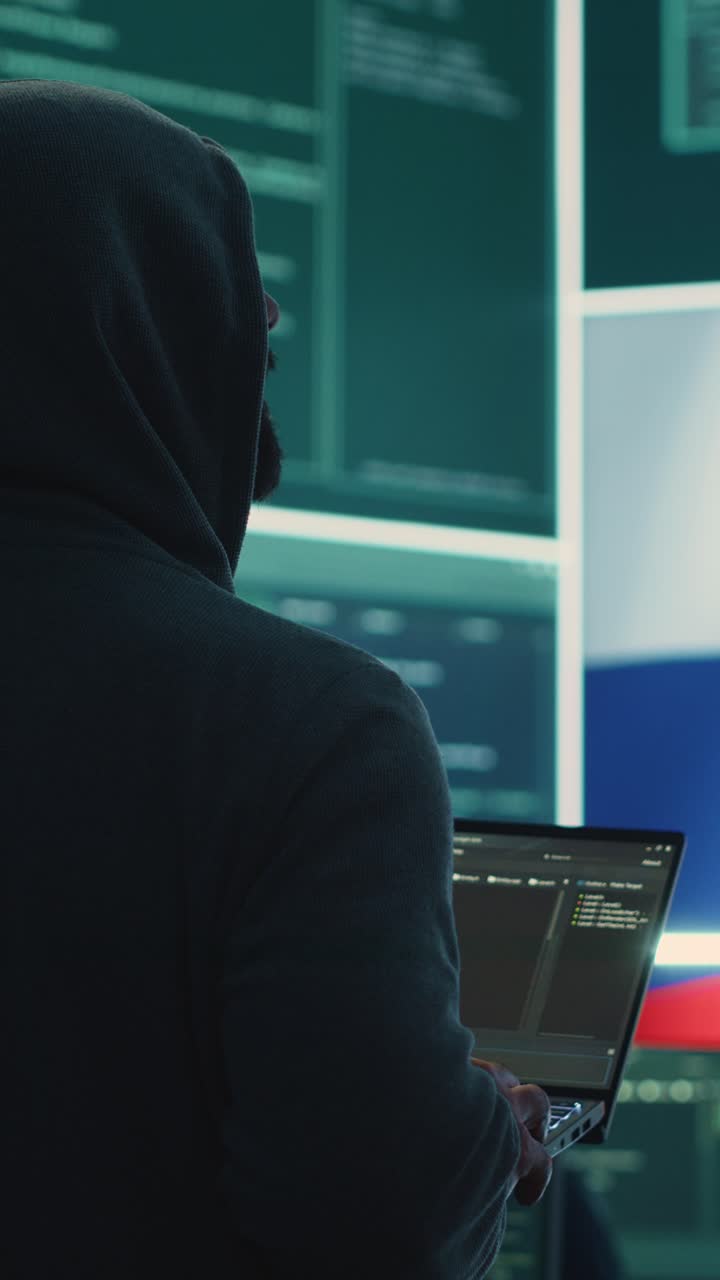 Hacker incappucciato che digita su un laptop con la bandiera russa visualizzata