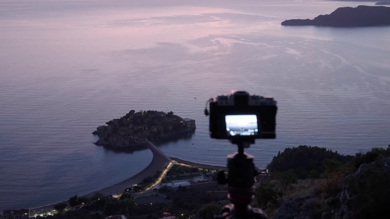 Sunset overlooking the coastline in Montenegro near Sveti Stefan. Camera taking photos of the coastline during sunset