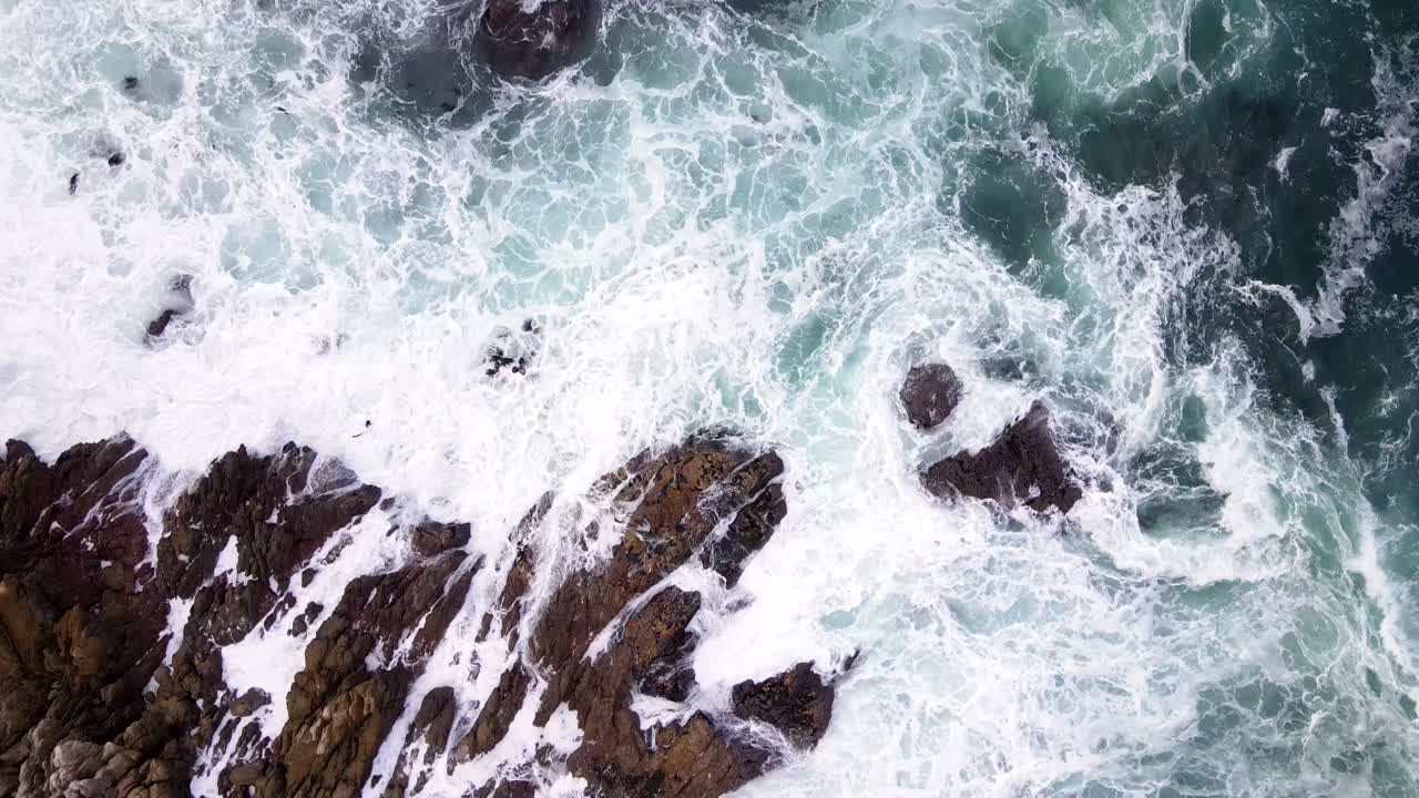 Top down aerial slomo view as Atlantic waves smash into jagged coastline