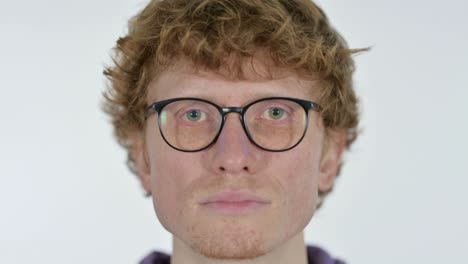 close up of serious face of redhead young man, white background