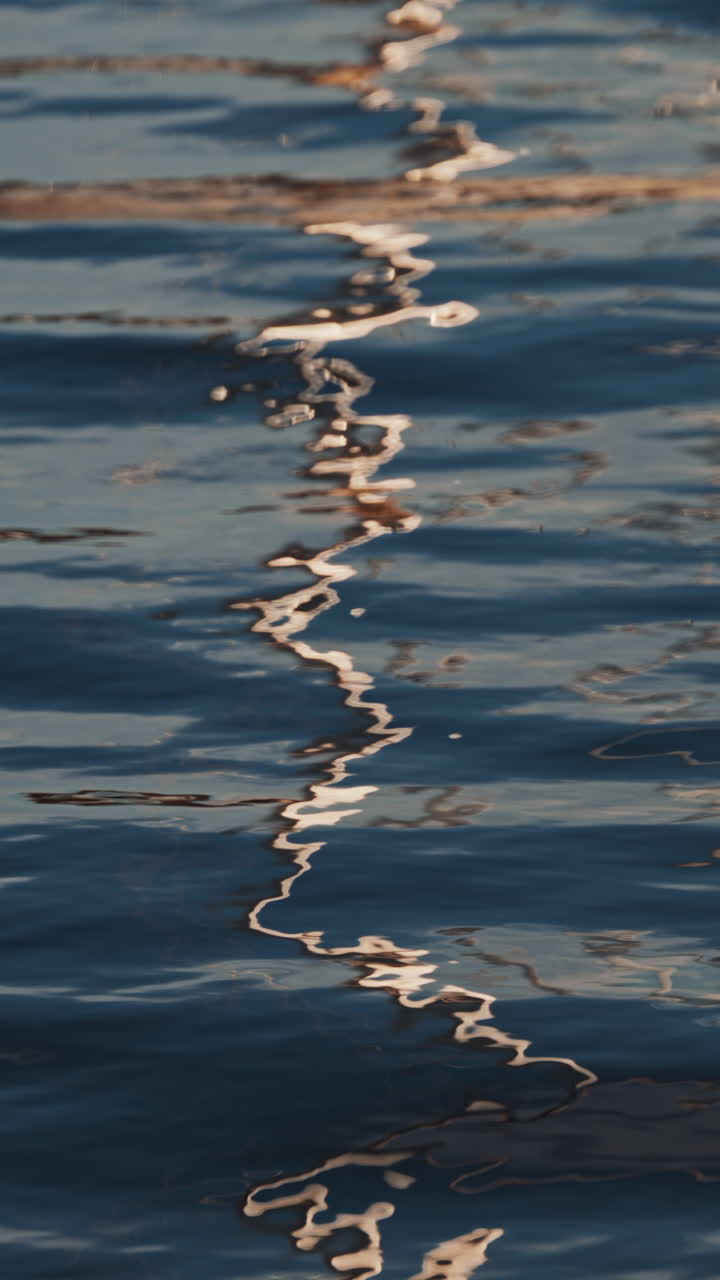 Reflections of the city on the waves of the sea. Vertical