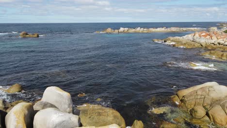 drone aerial over crystal blue water on summer bay bay of fires tasmania slow motion 60fps