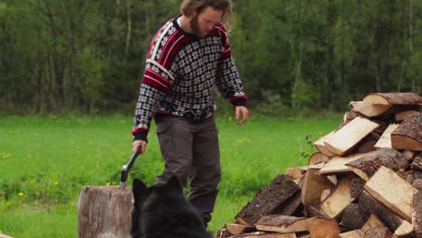 man chopping a log with an ax - wide