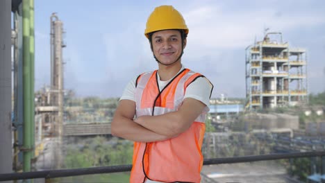 retrato de un feliz trabajador de la construcción indio de pie con las manos cruzadas