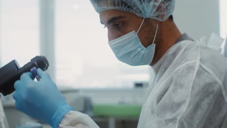 científico trabajando con el microscopio en un laboratorio