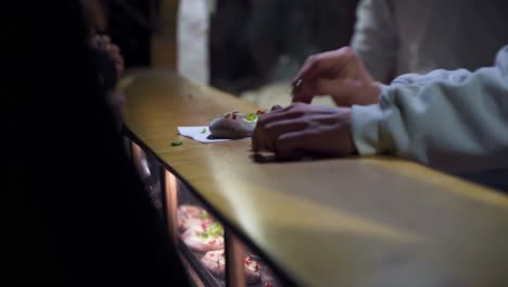 Stall-Owner-Sells-Hot-Loaves-Russian-Bread-To-Customer-in-Berlin-Night-Christmas-Market