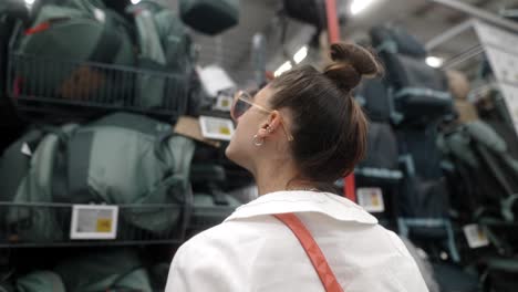 woman looking at backpacks in a store