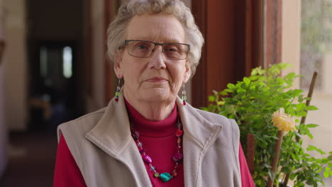 retrato de una anciana confiada de pie junto a la ventana sonriendo orgullosa disfrutando de la jubilación