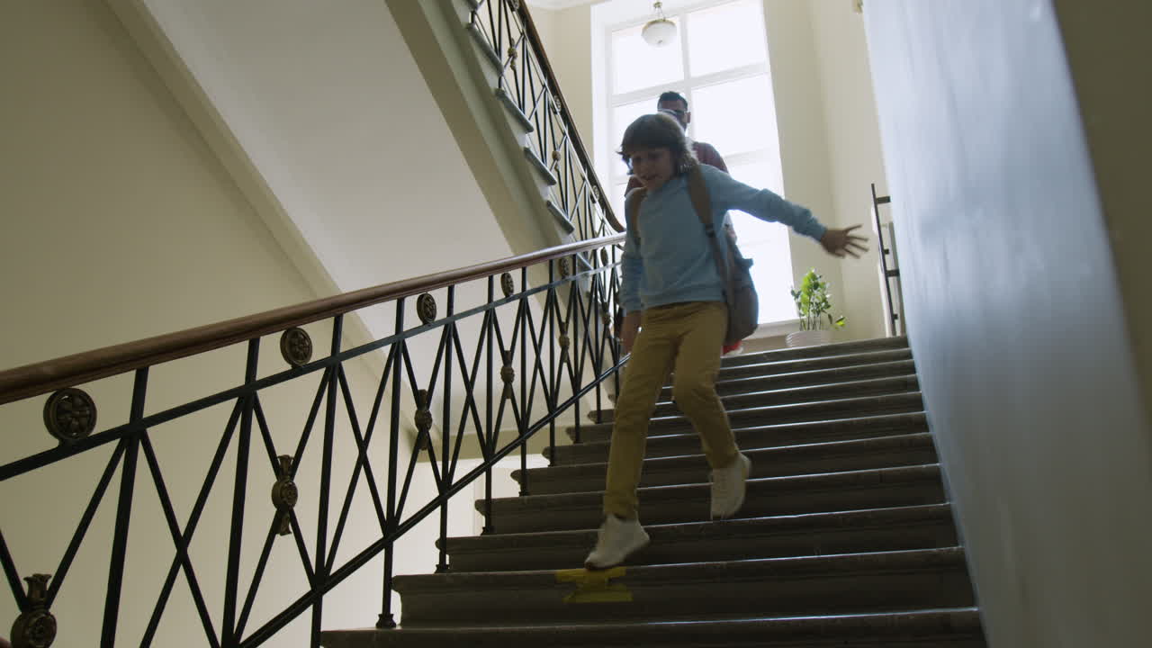Students and adults walking down stairs in a school building