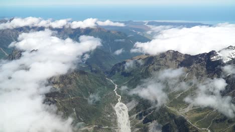 toma aérea desde un vuelo panorámico sobre la costa oeste del glaciar fox aoraki mount cook, parque nacional con nubes, montañas rocosas nevadas y océano en el fondo
